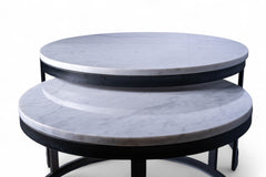Two round marble tables stacked on top of each other with a white background