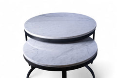 Two round marble tables with black metal bases on a white background
