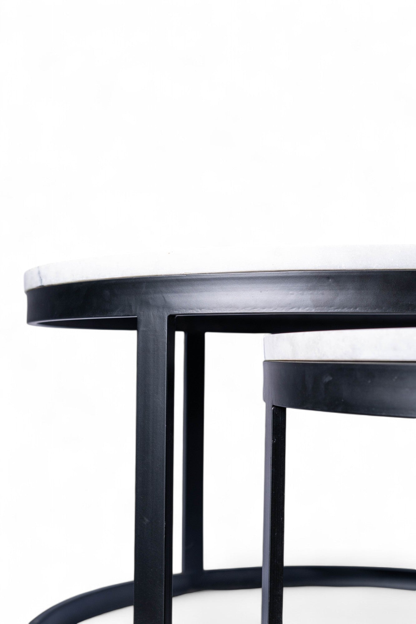 Round black table with a white marble top on a white background