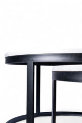 Round black table with a white marble top on a white background