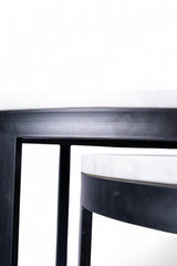 Close-up of a black metal stool on a white background
