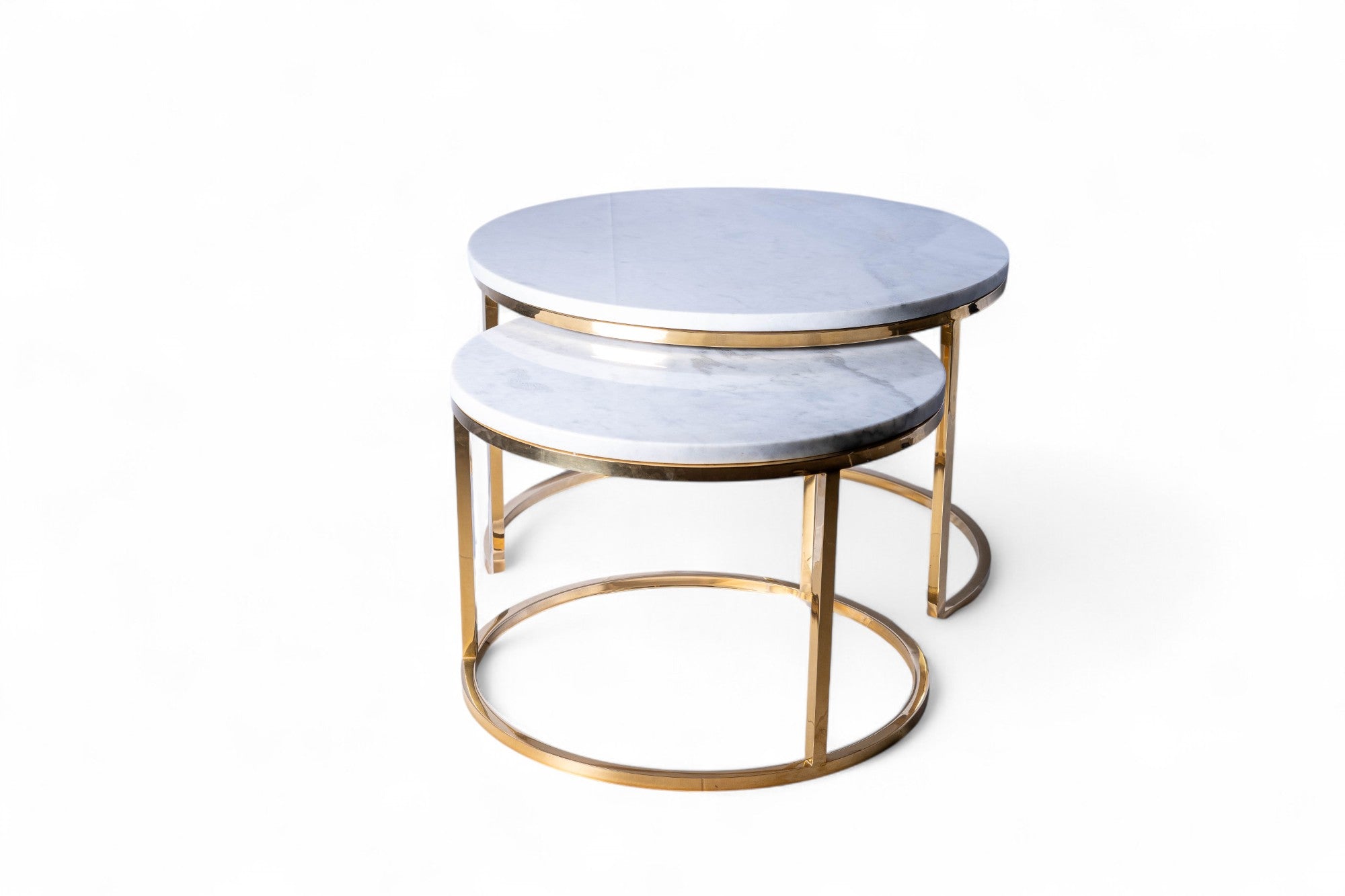Set of two round marble tables with gold metal bases on a white background