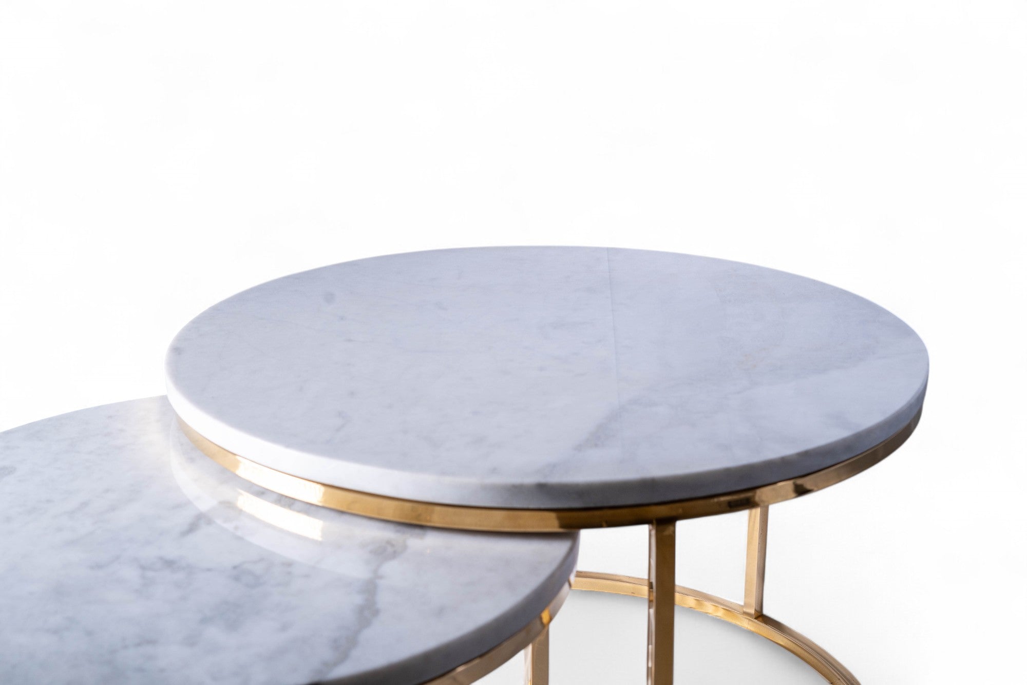 Set of marble coffee tables with gold trim on a white background