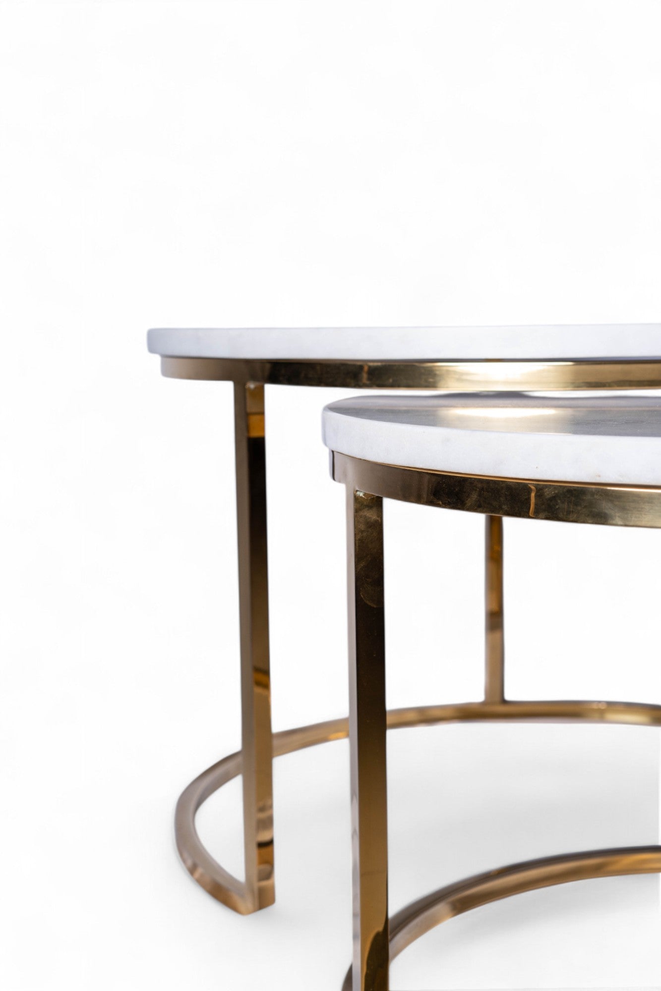 Two round tables with marble tops and gold metal frames on a white background