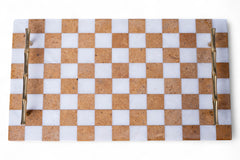 Checkered cutting board with gold handles on a white background