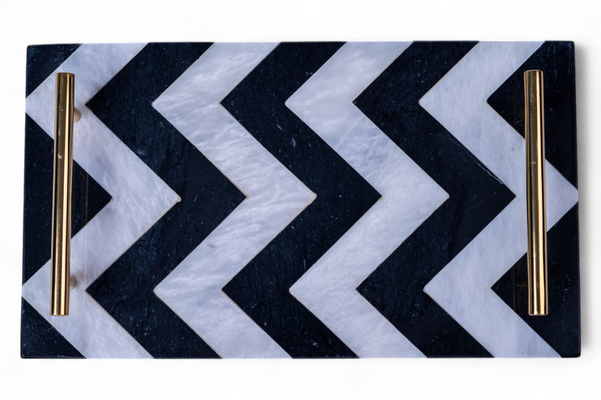 Black and white chevron patterned tray with gold handles on a white background