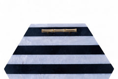 Hexagonal marble box with black and white striped pattern and gold handle on a white background
