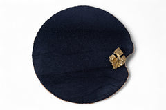 Navy blue cloche hat with a gold brooch on a white background