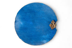 Blue round object with a gold decorative element on a white background