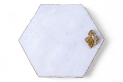 Hexagonal white tile with a gold fish design on a white background