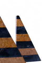 Two triangular objects with black and brown striped pattern on a white background