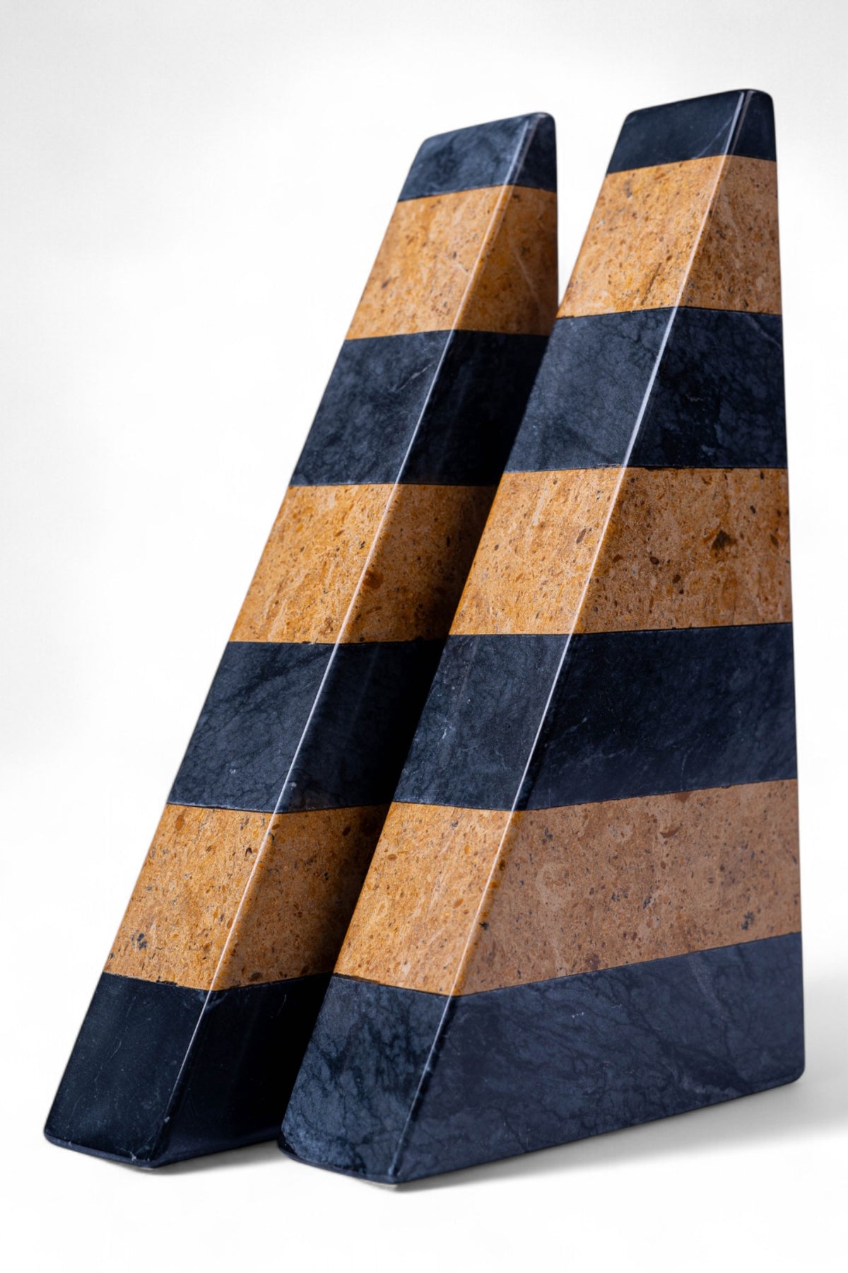 Two wedge-shaped objects with alternating brown and blue stripes on a white background