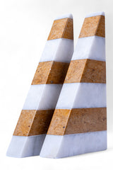 Three geometric stone blocks with striped pattern on a white background