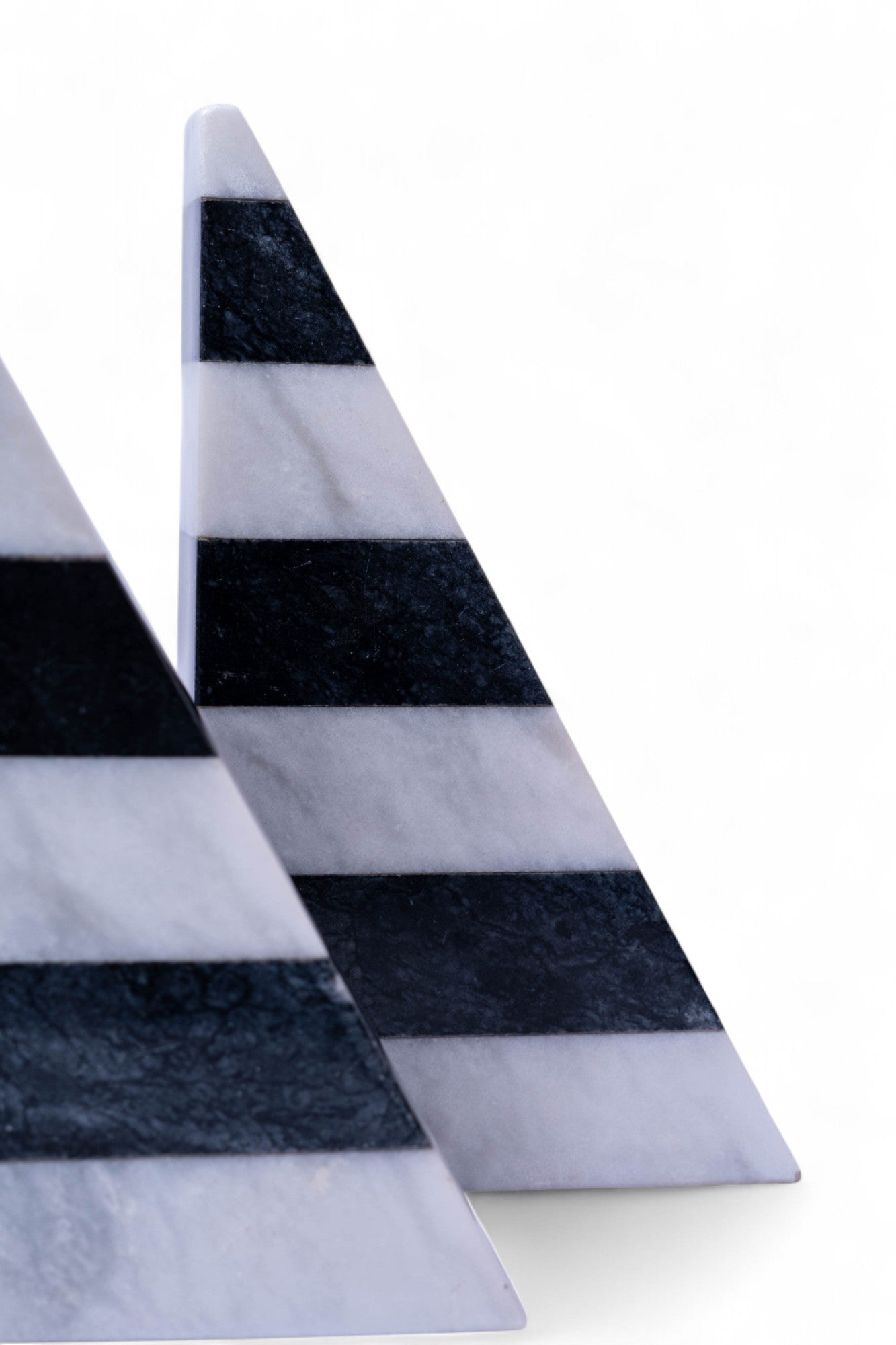 Two triangular marble slabs with black and white stripes on a white background