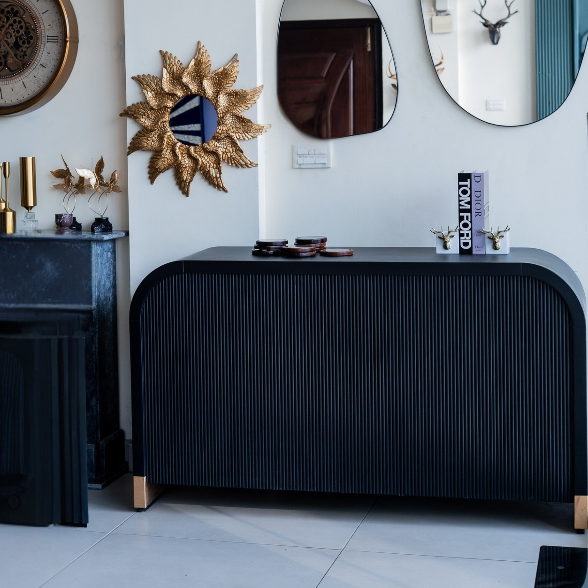 Modern interior with black console table, decorative mirrors, and wall art.