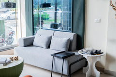 Modern living room with a gray sofa, coffee table, and decorative items.