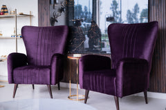 Two purple armchairs in a modern interior setting with a glass table and decorative items.