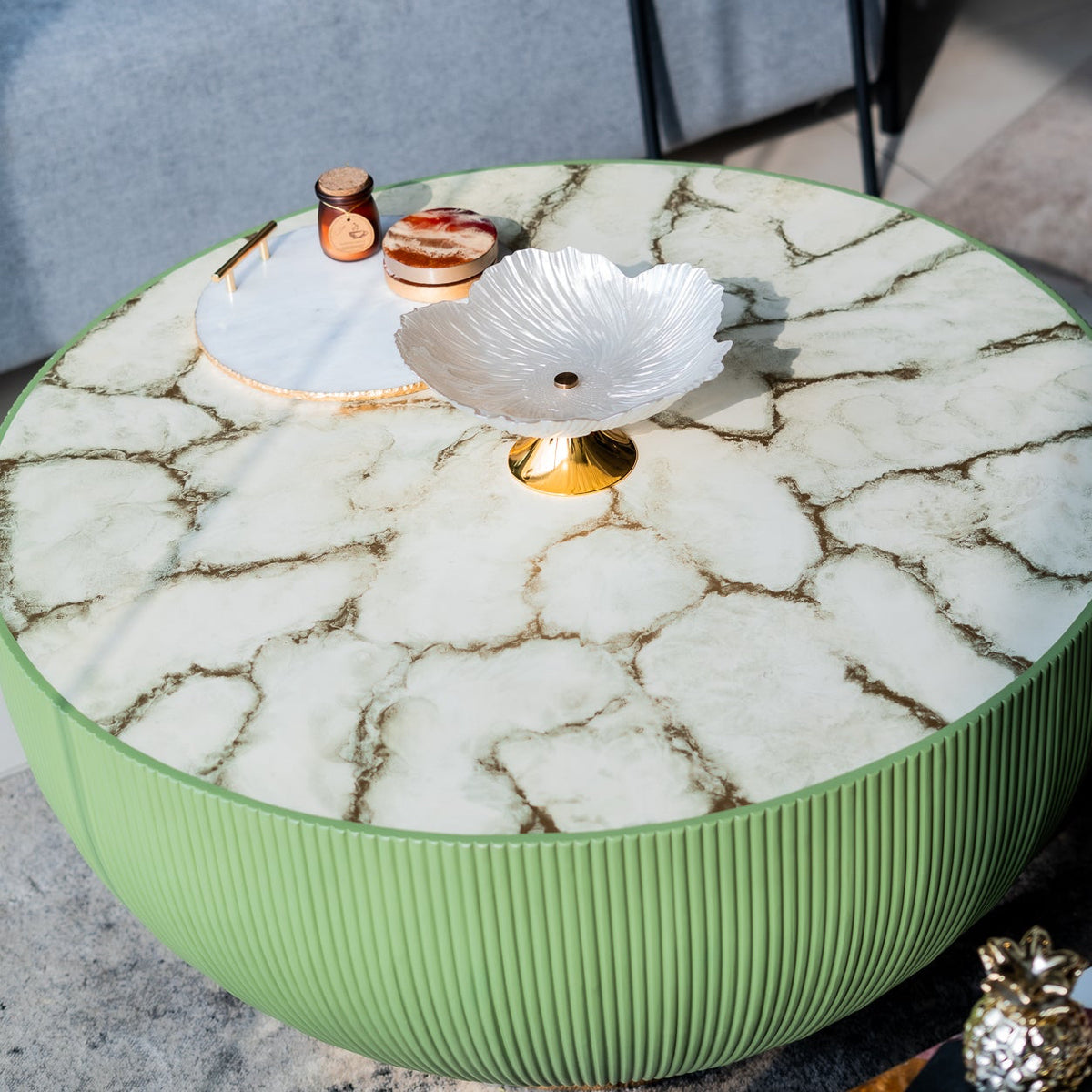 Round marble coffee table with decorative items on a blurred background