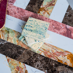 Stack of speckled stone tiles on a marble surface