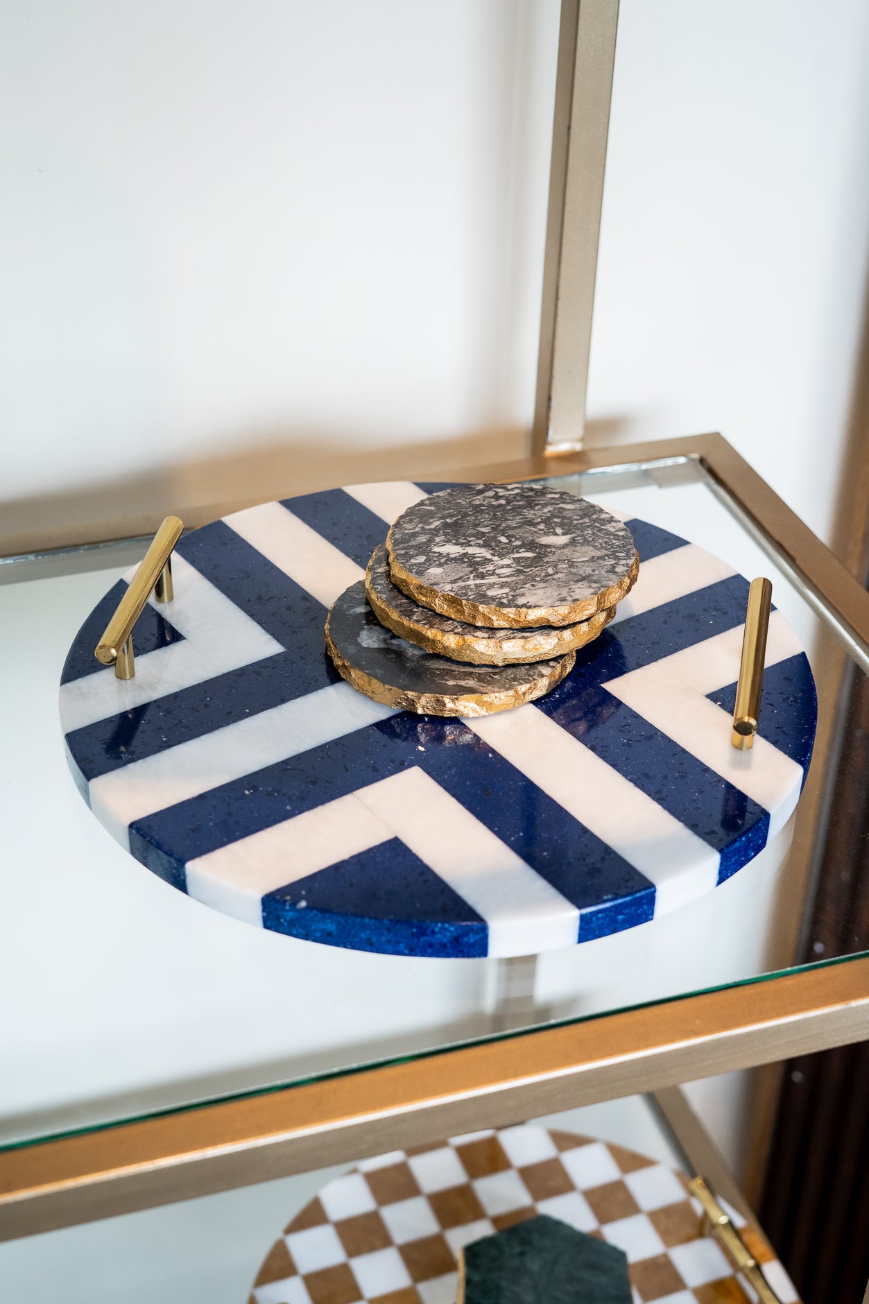 Round marble cutting board with blue and white pattern on a glass surface
