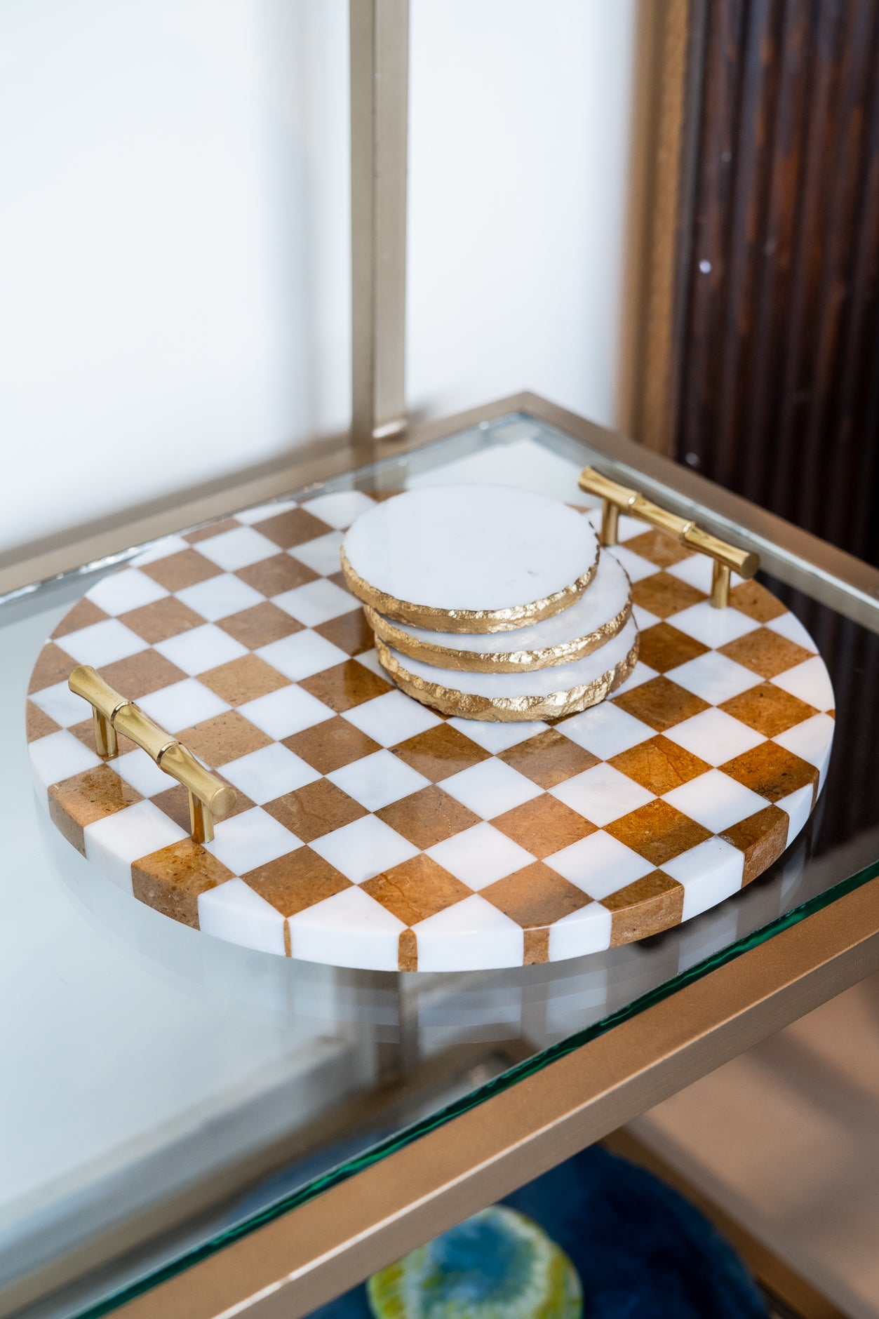 Checkered tray with gold accents on a glass surface