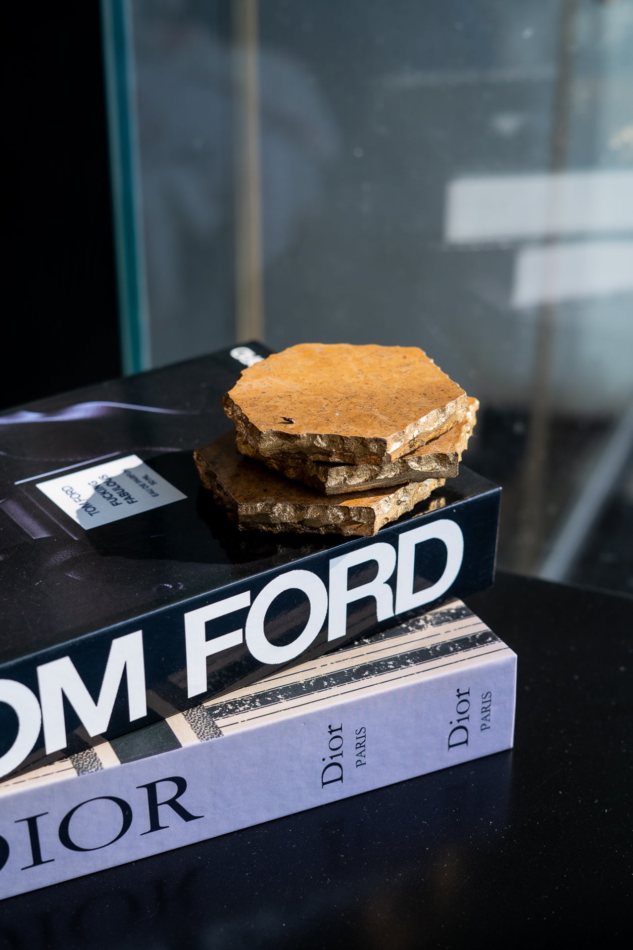 Book titled 'Dior' with a piece of cake on top, against a blurred background