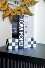 Decorative boxes with 'Tom Ford' and 'Dior' branding on a black surface.