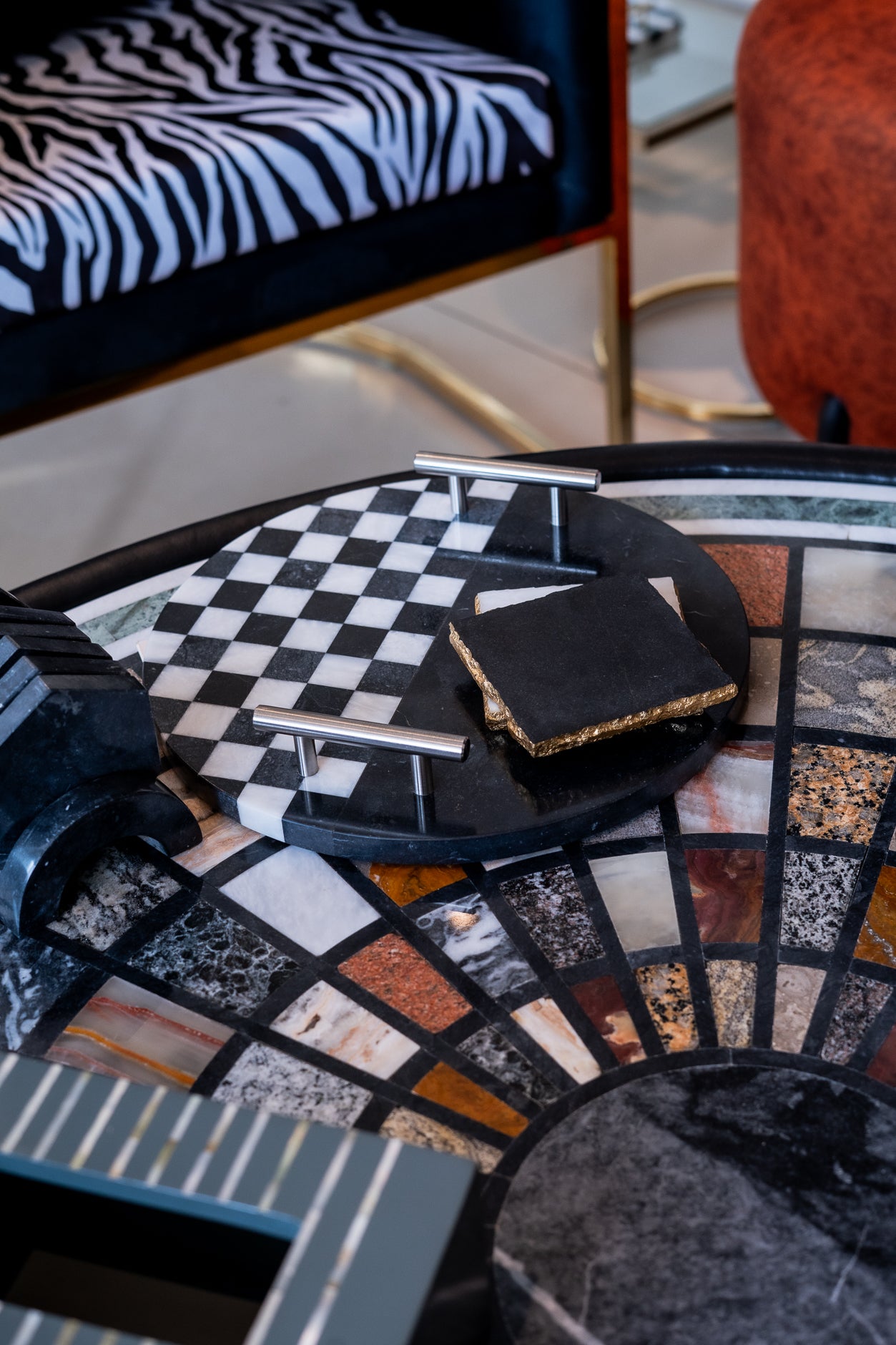 Decorative table with mosaic design and zebra-patterned chair in the background