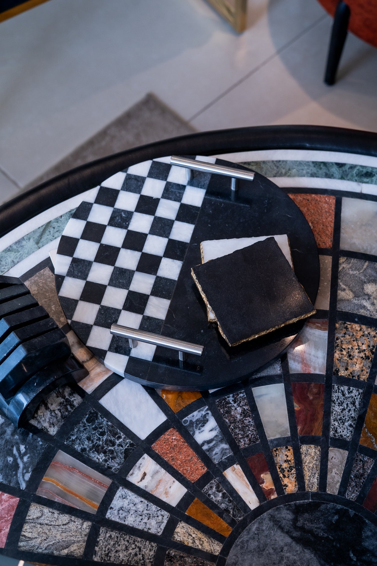 Black wallet on a checkered napkin on a mosaic-patterned table