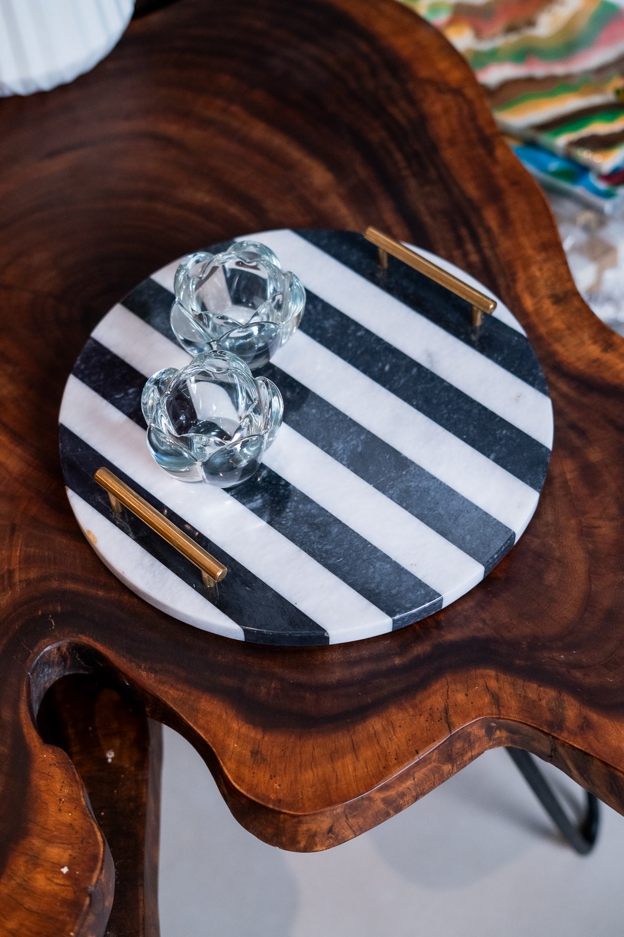 Round black and white striped tray with gold accents on a wooden surface