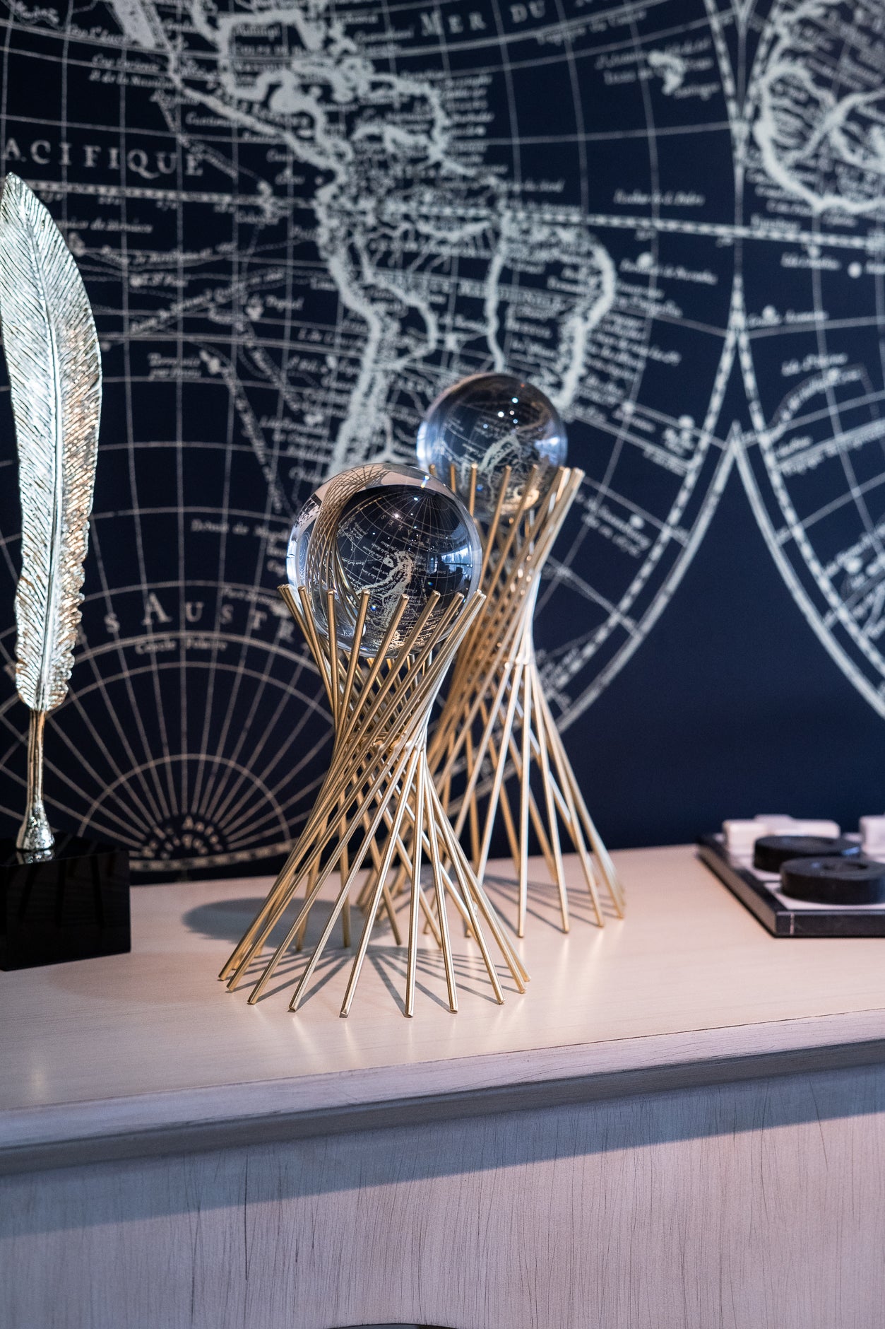 Decorative object with glass spheres on a surface in front of a world map.