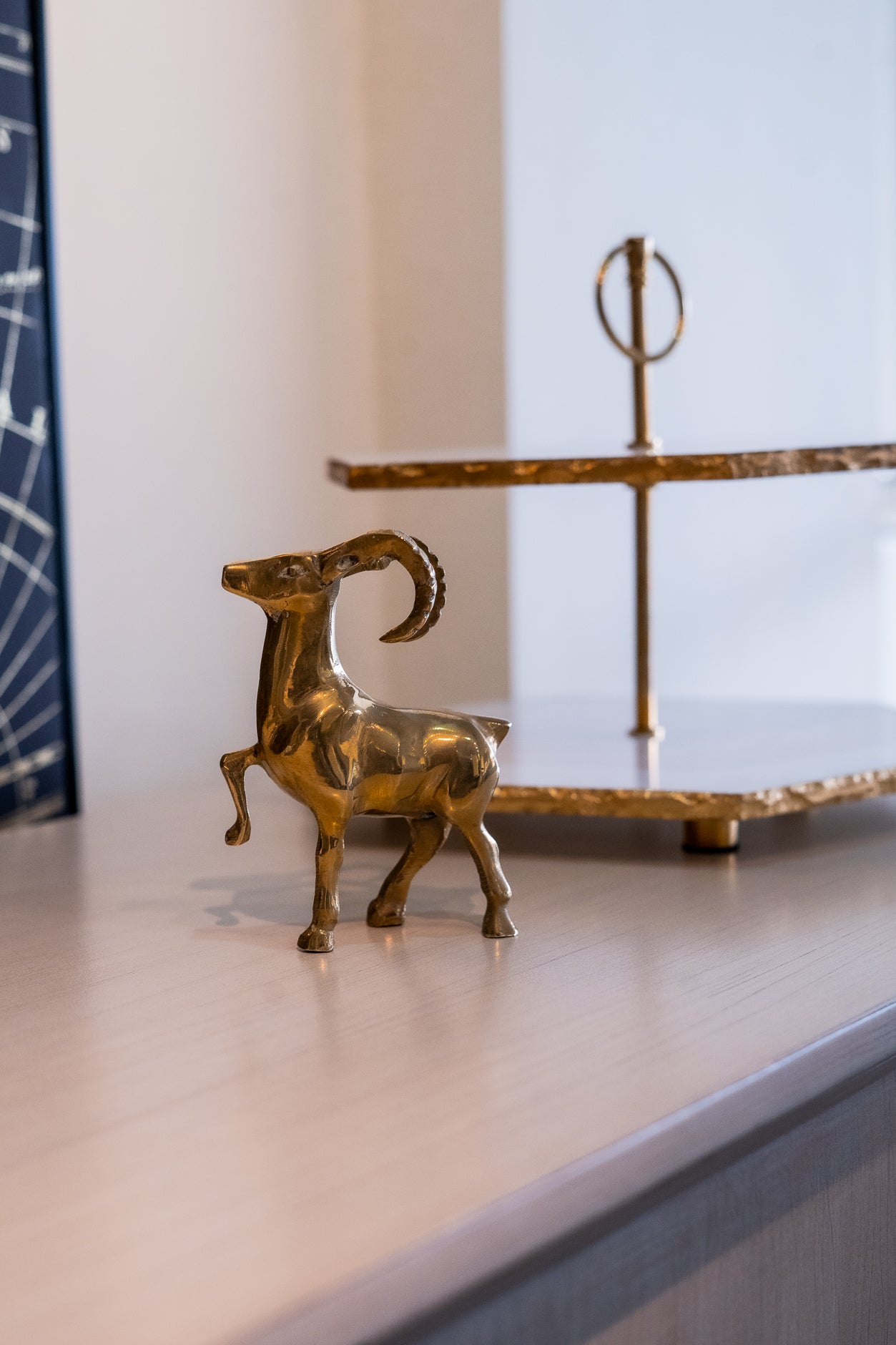Brass ram sculpture on a shelf with a blurred background