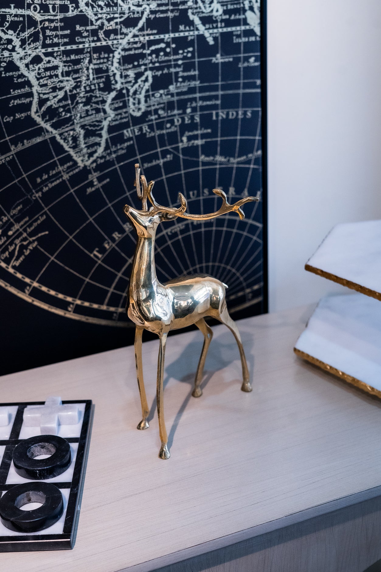 Gold deer figurine on a desk with world map in the background