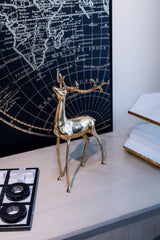Gold deer figurine on a desk with world map in the background