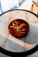 Wooden coaster with a gold design on a marble surface